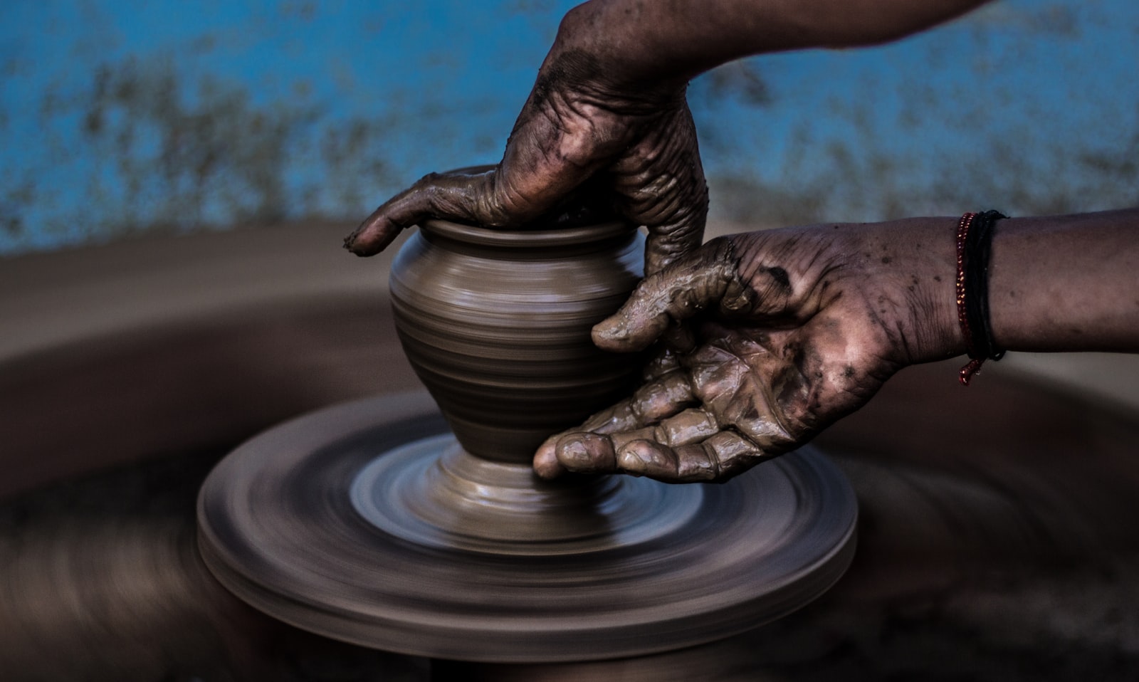 Hands shaping clay on a potter's wheel